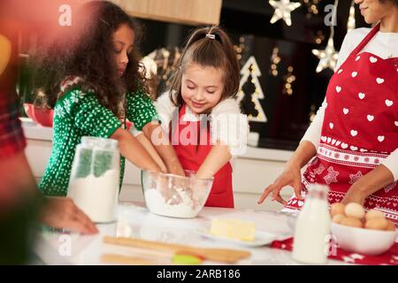 Family baking cookies together in Christmas time Stock Photo