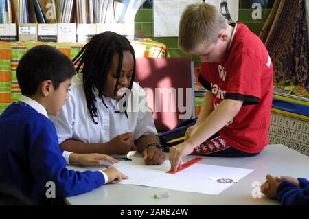 Primary students working together on a math problem using measurements Stock Photo