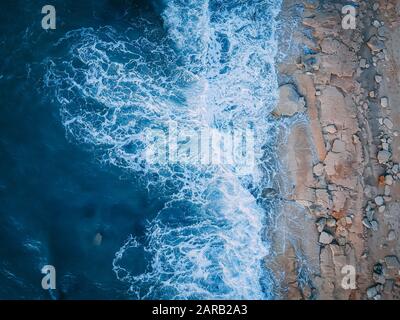 Elevated view of an ocean shoreline. Waves breaking on a sandy shore Stock Photo