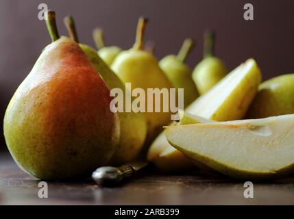 Fresh ripe pears on dark table against blurred background Stock Photo