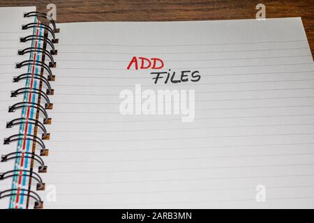 Add files, handwriting text on page of office agenda, office spiral notebook. Copy space. Stock Photo