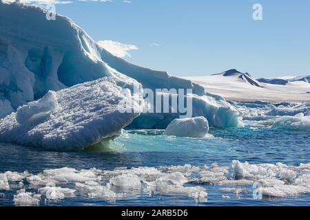 melting Iceberg with ice floe in foreground, floating in the sea, Antarctica Stock Photo