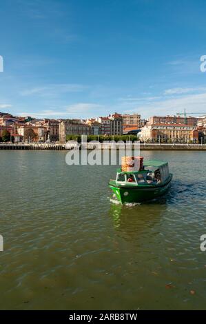 Green small boat carrying passengers across the River Nervion, between Portugalete and Las Arenas, Getxo, Vizcaya, Pais Vasco, Spain Stock Photo