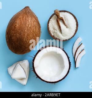 Coconut flour in a bowl with coconut pieces top view on a light blue background Stock Photo