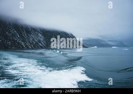 Waves crashing at the shore on an overcast day in the arctic circle in Greenland. Powerful ocean waves breaking.Wave breaks on a shallow bank. Natural