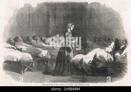 In Scutari, Florence Nightingale attends a patient during the night round.      Date: 1855 Stock Photo