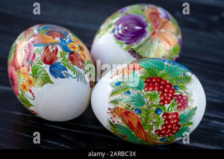 Paschal gift card with colorful easter eggs on dark wood background. Festive happy easter card Stock Photo