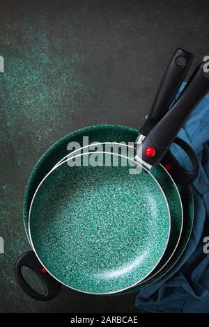 New set of non stick frying pans with ceramic coating on a stone kitchen table. Stock Photo
