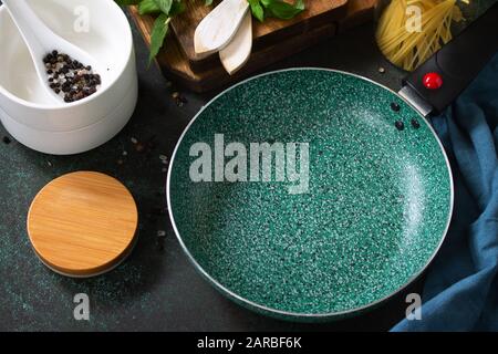New Empty fry pan with ceramic coatingon on a stone kitchen table surrounded by Italian cuisine ingredients. Stock Photo