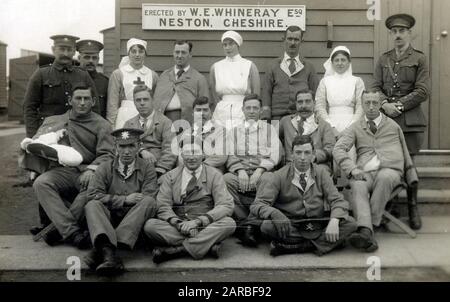 WW1 Home Front - British Red Cross Hospital at Netley - Group photograph of the patients, officers and nursing team outside their 'hut' erected by W. E. Whineray Esq. of Neston, Cheshire. William Whineray who had made a fortune from cotton, was a hearty philanthropist throughout the war years - he lived at Leighton Court in Neston and fitted up a workshop in his garden to manufacture munitions, probably shells cases or bullets. Stock Photo