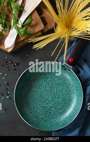 Empty fry pan with ceramic coatingon on a stone kitchen table. Top view flat lay background. Stock Photo