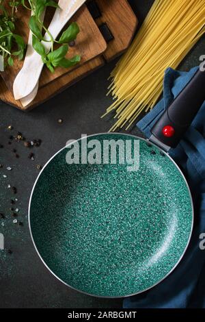 Empty fry pan with ceramic coatingon on a stone kitchen table. Top view flat lay background. Stock Photo