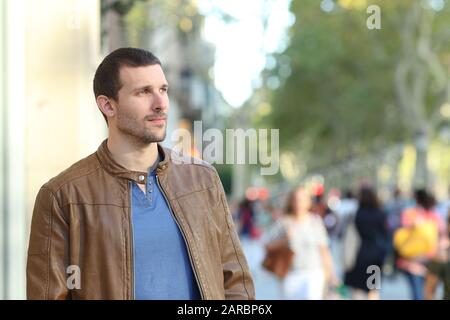 Adult handsome man walking looking away in the street Stock Photo