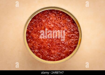 Orange salmon caviar in a tin can on craft brown paper. Red caviar in a jar close-up, seafood. Delicacy food concept Stock Photo