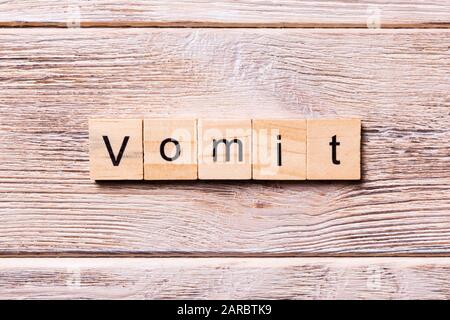 vomit word written on wood block. vomit text on wooden table for your ...