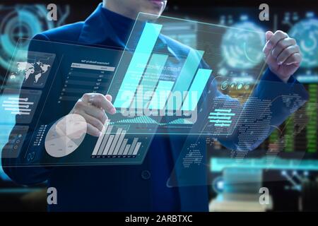 Businessman holding futuristic virtual modern computer augmented reality touch screens analysing on investment risk management and return on investmen Stock Photo