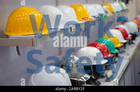 Variety color of safety helmets on shelf of warehouse store with work safety words Stock Photo