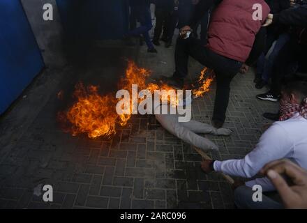 January 27, 2020, Gaza City, The Gaza Strip, Palestine: Palestinian demonstrators prepare to set an effigy depicting US President Donald Trump on fire during a protest against his Middle East peace plan, on January 27, 2020 in Gaza City. - Palestinian prime minister Mohammed Shtayyeh called today for international powers to boycott a US peace plan which they see as biased towards Israel as Israeli Prime Minister Benjamin Netanyahu and his political rival Benny Gantz are set to meet Donald Trump in Washington, with the US President expected to reveal his long-delayed proposal for Israeli-Palest Stock Photo