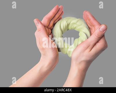 Sticky slime in the hand. The green slime in hands. Favorite toy for a child. Hobby, pleasant to the touch anti-stress trainer Stock Photo