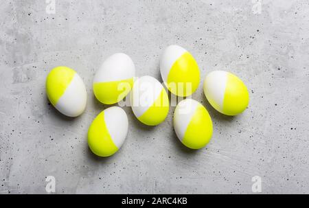 Eggs painted in white and yellow on a gray background Stock Photo