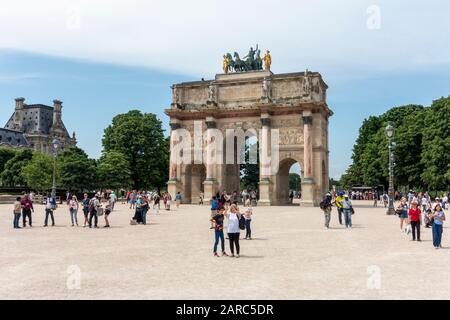 Visitors around the Arc de Triomphe du Carrousel next to the Louvre Museum (Musée du Louvre) in Tuileries Quarter of Paris, France Stock Photo