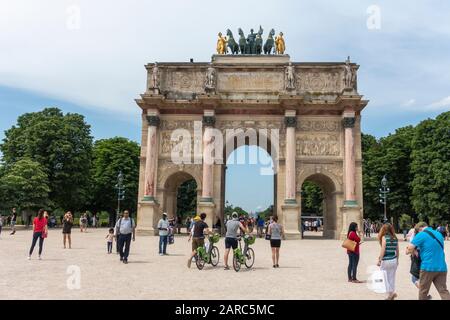 Visitors around the Arc de Triomphe du Carrousel next to the Louvre Museum (Musée du Louvre) in Tuileries Quarter of Paris, France Stock Photo