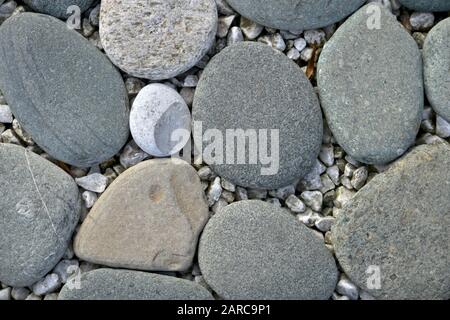 Large smooth different in shape and color stones on small sharp. Stock Photo