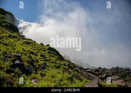 Landscape of rocks covered in mosses with the Niagara falls under the sunlight on the background Stock Photo