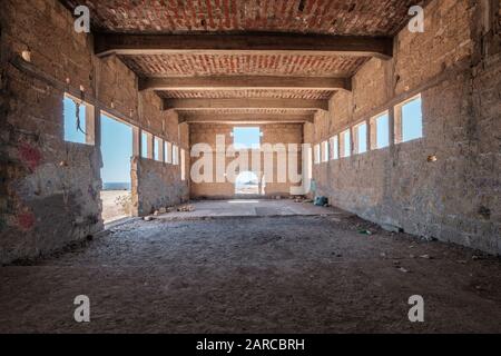 inside of abandoned warehouse or industrial ruin - run down building , empty space Stock Photo