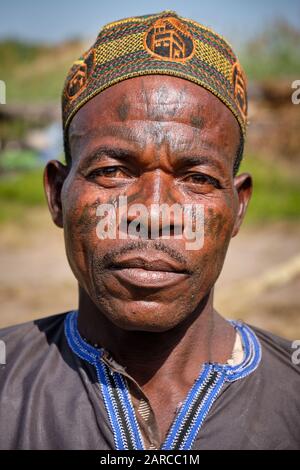 Portrait of a Fulani man with facial tattoos and a muslim cap. Stock Photo