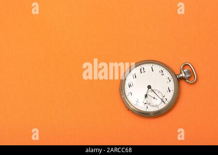 Clock on an orange surface - time management concept Stock Photo