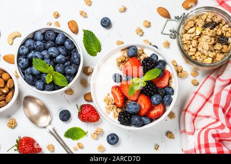 Greek yogurt granola with fresh berries on white table. Stock Photo