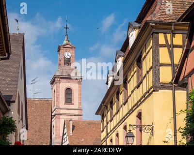 Medieval half timbered buildings and a church bell tower in Colmar Alsace France