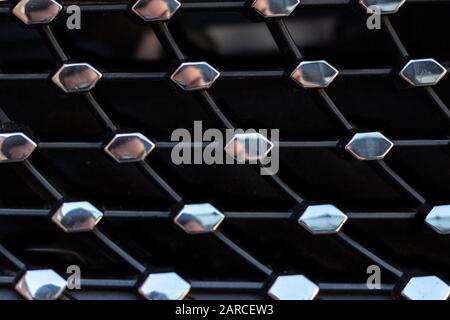 Closeup shot of hexagonal shiny metal pieces attached to a black surface Stock Photo