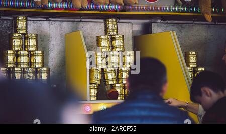 Cans stacked on top of each other behind two men Stock Photo