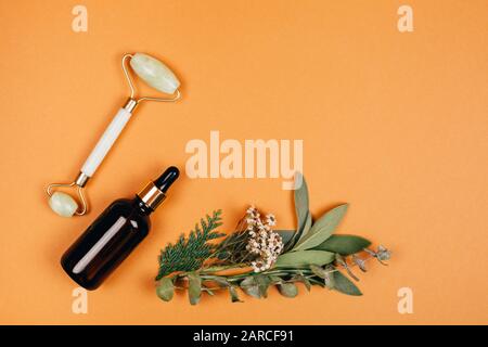 Modern apothecary with natural ingredients. Oil made of herbs herbs. Face roller for self-care. Flat lay style. Stock Photo