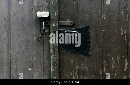 Close up of old and new iron locks on wooden door. Technological change, security concepts. Stock Photo