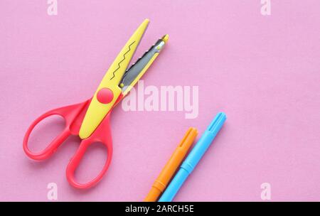 scissors, ruler and crayons on a pink background. Creative, fashionable, minimalistic, school or office workspace with yellow supplies for handycraft Stock Photo