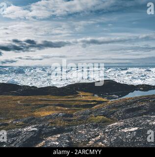 View towards Icefjord in Ilulissat. Easy hiking route to the famous Kangia glacier near Ilulissat in Greenland. The Ilulissat Icefjord seen from the Stock Photo