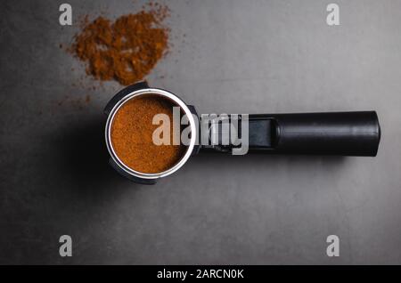 Top view of portafilter with ground coffee over black background and place for text Stock Photo