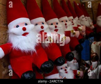 plush figurines of Santa Claus with bells on a street stand Stock Photo