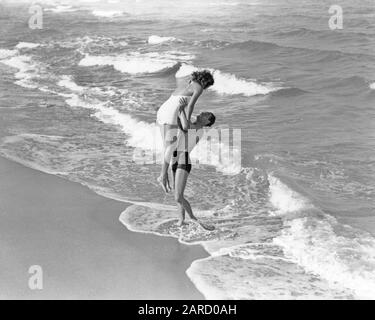 1930s 1940s VACATION COUPLE WEARING BATHING SUITS PLAYING IN SURF AT BEACH  WOMAN RUNNING TOWARD SMILING MAN FLORIDA USA - b7126 HAR001 HARS 1 FITNESS  SILLY TROPICAL HEALTHY COMIC VACATION STRONG JOY