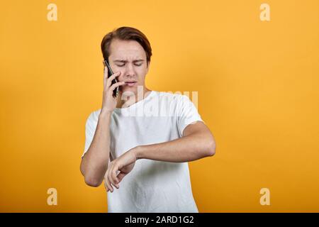 Business man financial manager talking on the phone in the yellow background. Stock Photo