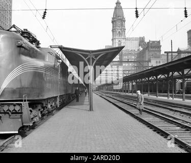 1930s PENNSYLVANIA RAILROAD GG-1 ELECTRIC LOCOMOTIVE AT DOWN TOWN SUBURBAN STATION PHILADELPHIA PENNSYLVANIA USA - q41874 CPC001 HARS UNITED STATES COPY SPACE FULL-LENGTH PERSONS UNITED STATES OF AMERICA MALES TRANSPORTATION B&W NORTH AMERICA NORTH AMERICAN RAIL SKILL OCCUPATION PLATFORM SKILLS CITY HALL CUSTOMER SERVICE EXTERIOR PA POWERFUL PROGRESS LOCOMOTIVE LOCOMOTIVES OCCUPATIONS NORTHEASTERN COMMONWEALTH CONNECTION CITIES KEYSTONE STATE STYLISH RAILROADS ANONYMOUS GENERAL ELECTRIC PRR 1934 BLACK AND WHITE CITY OF BROTHERLY LOVE COMMUTER OLD FASHIONED Stock Photo