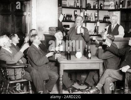 1930s NINE MEN TOASTING AT THE BEVERLY CLUB A CHARACTER WHO SAT FOR THE F. W. ELWELL PAINTING A MAN WITH A PINT - q75028 CPC001 HARS HALF-LENGTH PERSONS CHARACTER MALES PINT SENIOR MAN ENGLISH SENIOR ADULT B&W BRITAIN PUB CELEBRATING HAPPINESS OLDSTERS CHEERFUL OLDSTER RECREATION TOASTING PRIDE SMILES ELDERS WHO INEBRIATED JOYFUL LIQUOR NINE SAT ELDERLY MAN 9 BOOZE COOPERATION TOGETHERNESS BLACK AND WHITE CAUCASIAN ETHNICITY GREAT BRITAIN OLD FASHIONED UNITED KINGDOM Stock Photo