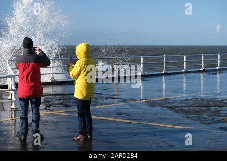 Aberystwyth Ceredigion Wales UK January 17 2019: Couple photographing the high waves using their mobile cell phones. Stock Photo