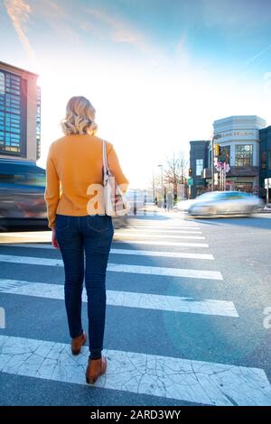 USA Maryland Bethesda Pedestrian safety woman crossing in a crosswalk with car traffic Stock Photo