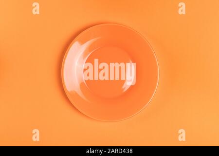 Empty orange plate on orange background. Top view Stock Photo