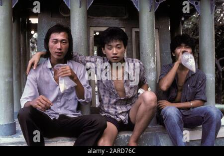 YOUNG MEN IN SINGAPORE GLUE SNIFFING. ALSO KNOWN AS BAGGING, GLADING, DUSTING OR HUFFING. Stock Photo