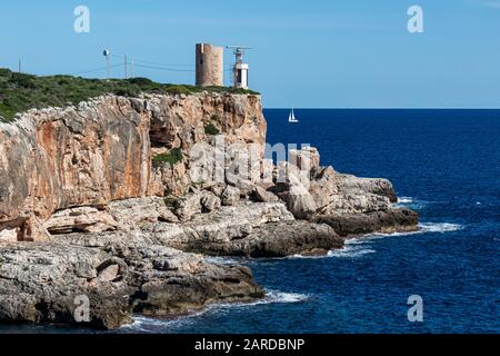 Old watchtower Torre d'en Beu, also Torre de Cala Figuera, alongside with small lighthouse on cliff at Cala Figuera, Mallorca, Balearic Islands, Spain Stock Photo